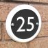 Round house number in matt white ceramic with choice of coloured background